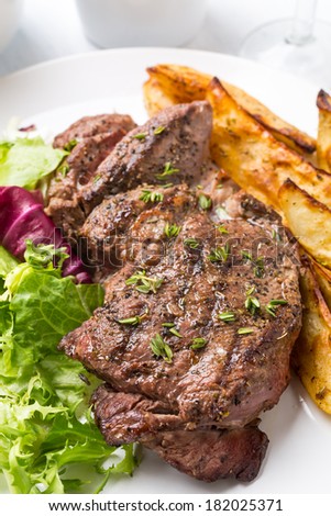 Grilled Rib-eye Beef Steak with Green Salad and Herb Potato Wedges