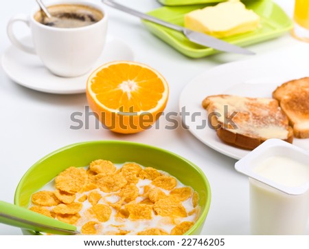 nutritious breakfast meal with a bowl of cornflakes, two pieces of toast, an orange and a cup of coffee