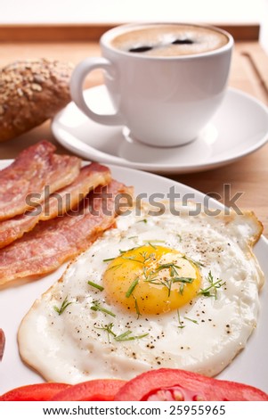 classic breakfast with fried egg, sausages, bacon and coffee