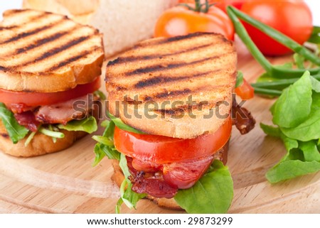 Bacon, lettuce and tomato BLT sandwiches with fresh ingredients at back