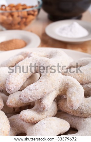 horse-shoe shaped homemade vanilla and almond cookies with ingredients and a mortar