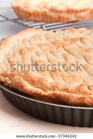 two pies - closed pie on a wooden board and open on a metal railing