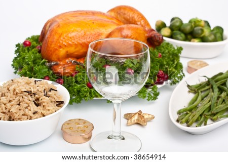 whole roasted chicken with parsley and cranberries on a dish, rice, green beans and Brussels sprouts