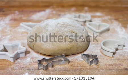 Gingerbread dough with forms on pastry board.
