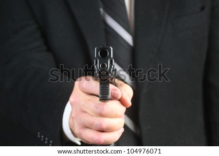 Business Man with a Gun/View of man\'s suited torso pointing .45 acp at camera.