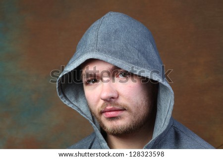 Man in Gray Hoodie/headshot of lightly bearded man wearing gray hoodie against brown portrait background