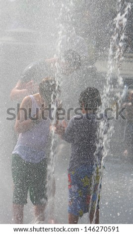 NEW YORK CITY - JULY 6 2013: The fountain at Washington Square Park becomes a major destination for overheated New Yorkers seeking escape from the summer heat on July 6 2013 in New York City.