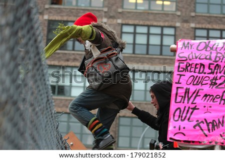 NEW YORK CITY, USA - DECEMBER 17 2011: Occupy Wall Street, protesting financial malfeasance, marked its 90 day anniversary with marches in Manhattan. Climbing over fence into Duarte Square