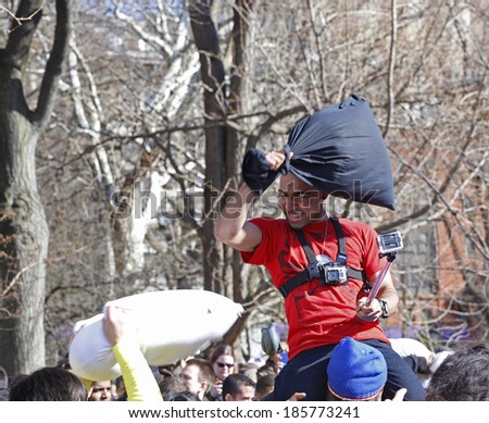 NEW YORK CITY - APRIL 5 2014: the first Saturday of April is International Pillow Fight Day, observed this time at Washington Square Park in Lower Manhattan. Fighter riding high on friend\'s shoulders