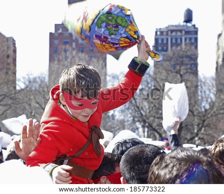 NEW YORK CITY - APRIL 5 2014: the first Saturday of April is International Pillow Fight Day, observed this time at Washington Square Park in Lower Manhattan. Child in mask reigning damage