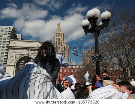 NEW YORK CITY - APRIL 5 2014: the first Saturday of April is International Pillow Fight Day, observed this time at Washington Square Park in Lower Manhattan. Young woman gaining height advantage