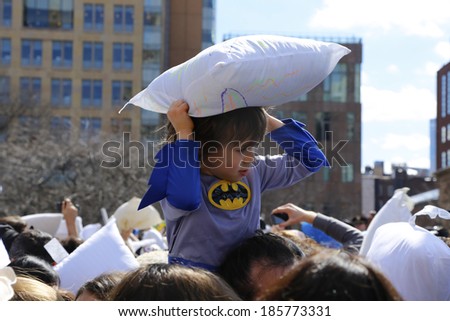 NEW YORK CITY - APRIL 5 2014: the first Saturday of April is International Pillow Fight Day, observed at Washington Square Park in Lower Manhattan. Boy in Batman shirt seeks targets from above