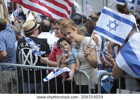 NEW YORK CITY - JULY 20 2014: several thousand supporters of Israeli actions in Gaza staged a rally in Times Square. Parents & child at barrier with US & Israeli flags