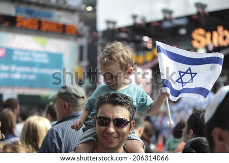 NEW YORK CITY - JULY 20 2014: several thousand supporters of Israeli actions in Gaza staged a rally in Times Square. Toddler riding father\'s shoulders clutching Israeli flag