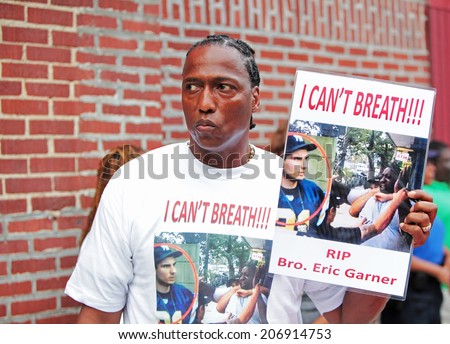 NEW YORK CITY - JULY 23 2014: Funeral services for Eric Garner, the Staten Island resident who died while being taken into custody by NYPD.  Activist with sign.