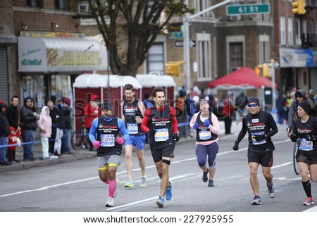 NEW YORK CITY - NOVEMBER 2 2014: the 43rd annual NYC Marathon saw more than 50,000 entrants race through all five boroughs. Footlocker team members passing mile four in Brooklyn