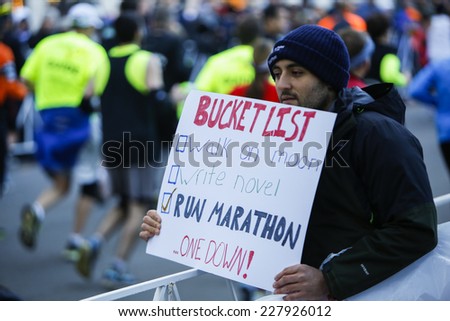 NEW YORK CITY - NOVEMBER 2 2014: the 43rd annual NYC Marathon saw more than 50,000 entrants race through all five boroughs. Spectator with bucket list sign that includes running in marathon