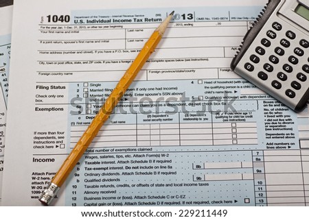 Internal Revenue Service form 1040 with chewed pencil & electronic calculator