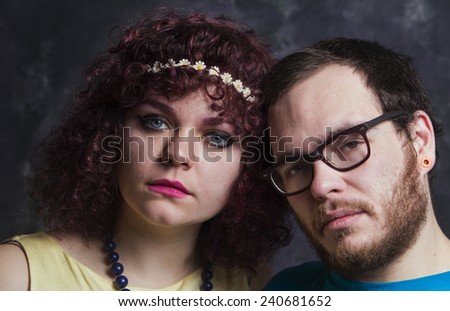 Hip, attractive couple pictured against portrait background