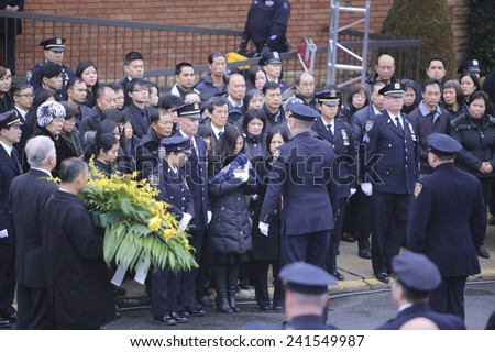 NEW YORK CITY - JANUARY 4 2015: several thousand police officers from all over North America attended funeral services for slain NYPD officer Wenjian Liu in Brooklyn. Presenting flag to widow.