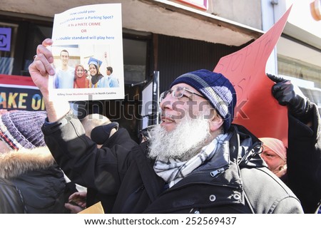 NEW YORK CITY - FEBRUARY 13 2015: Members of the Muslim community staged a vigil to call for justice in the killing of three Muslim Chapel Hill students. Activist with picture of slain students