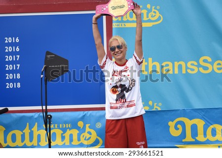 NEW YORK CITY - JULY 4 2015: Nathan\'s Famous staged its annual fourth of July hot dog eating contest in Coney Island, Brooklyn. Defending champion Miki Sudo holds up her Mustard Yellow belt