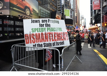 NEW YORK CITY - JULY 22 2015: thousands rallied in Times Square to oppose the President\'s proposed nuclear deal with Iran. Neturei Karta members with anti-Zionist signs behind crowd control barriers