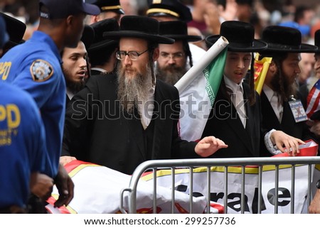 NEW YORK CITY - JULY 22 2015: thousands rallied in Times Square to oppose the President\'s proposed nuclear deal with Iran. Anti-zionist Neturei Karta members with NYPD community affairs personnel