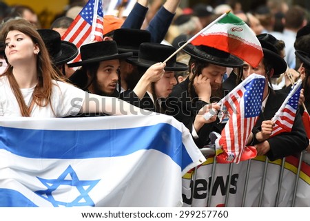 NEW YORK CITY - JULY 22 2015: thousands rallied in Times Square to oppose the President's proposed nuclear deal with Iran. Attempts to block anti-zionist Neturei Karta members with Israeli flag