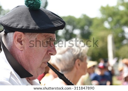 NEW YORK CITY - AUGUST 30 2105: The 239th anniversary of the Battle of Brooklyn was reenacted in Green-Wood Cemetery in Brooklyn. Bagpipe player atop Battle Hill