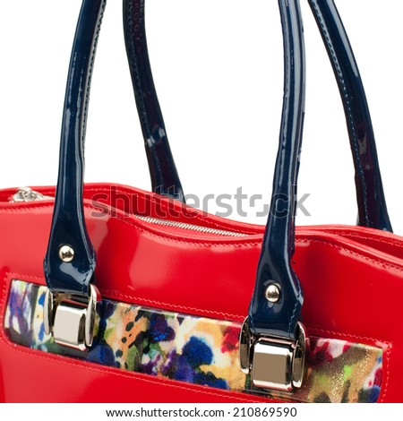 Red patent female leather bag with motley detail isolated on white.