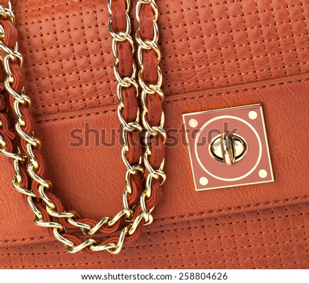 Burnt orange patent clutch isolated on white background.