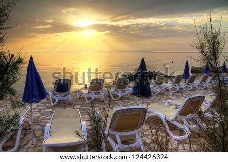 beds and parasols looking out over the sea at sunset. HDR