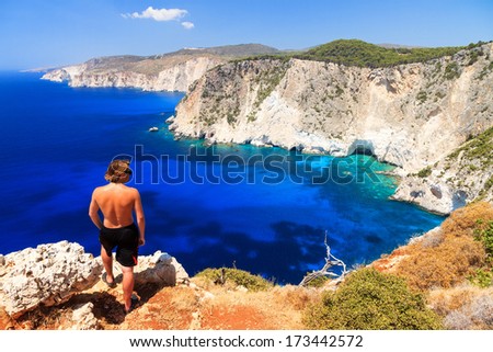 Young man on top of the cliff at Cape Keri on the island Zakynthos, Greece