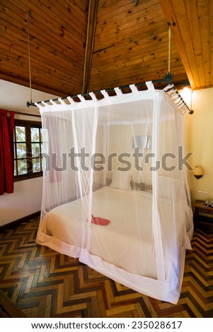 ANDASIBE, MADAGASCAR - SEPTEMBER 11, 2013: Mosquito net over a bed in a luxurious lodge in the tropics to save tourists near Andasibe, Madagascar, on September 11, 2013