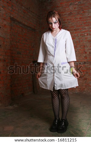 The strange girl in a hospital dressing gown costs in a cellar