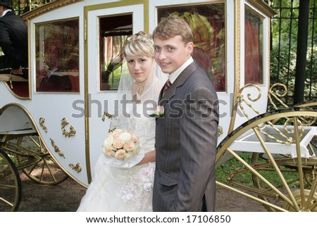 Happy newly-married couple about the white carriage