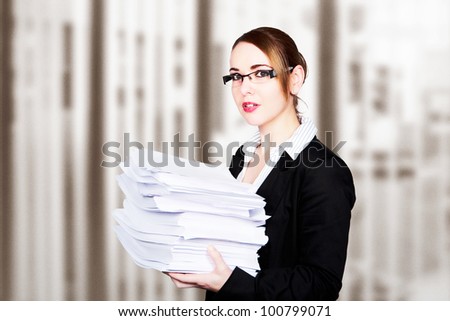 woman at her desk looking at all the paper work she has to do
