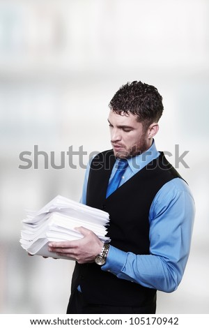 man holding a large pile of paper work in his arms has lot of work to do