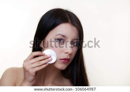 young girl wiping make up off her face