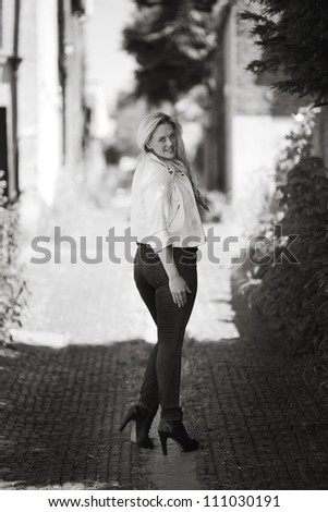 woman walking down a alleyway looking round back at the camera
