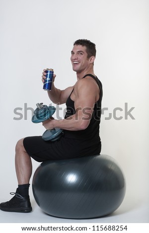 man sitting on a gym ball being tempted to give up and have a drink
