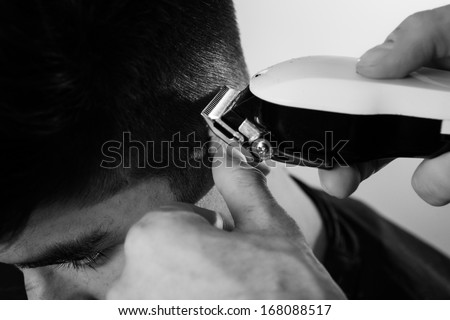 close up shot of man getting his hair cut going around his ear