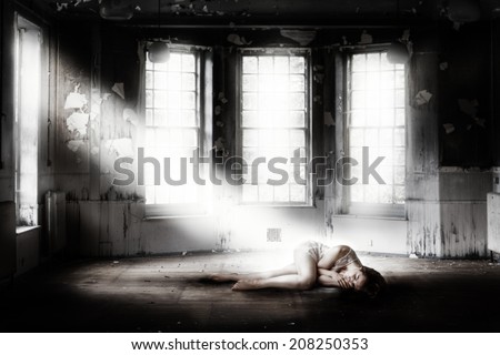 deserted run down building with a woman laying on the floor
