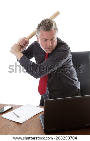 businessman getting very mad about to hit his computer with a baseball bat