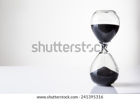 large hour glass sand timer with a lot of sand in it, time runs our slowly
