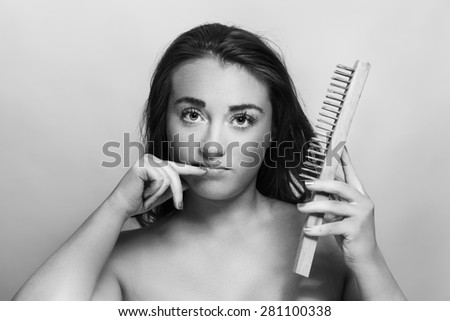 woman holding a wire brush as if she is going to use it to exfoliant hers skin
