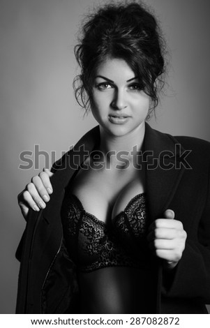 shot of a sexy woman in underwear wearing a large coat  shot in the studio