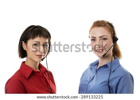 Two business woman wearing headset working hard to make you happy