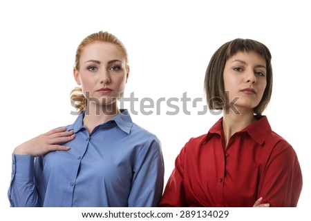 two business woman with different face expressions sanding side by side looking like diva\'s